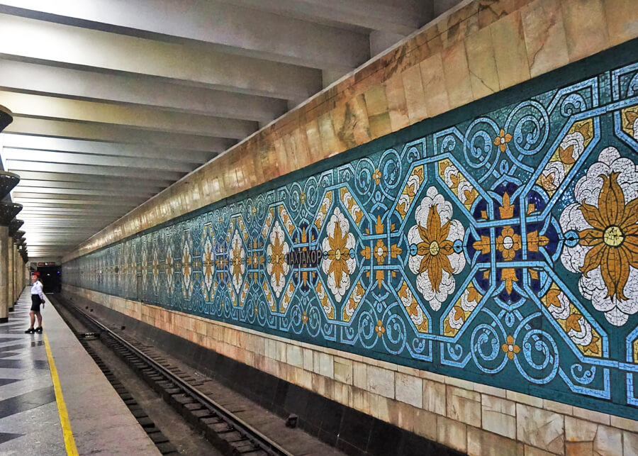 Un mozaic albastru, alb si auriu pe peretele unei statii de metrou ilustrand modele si motive florale la statia de metrou Pakhtakor din Taskent.